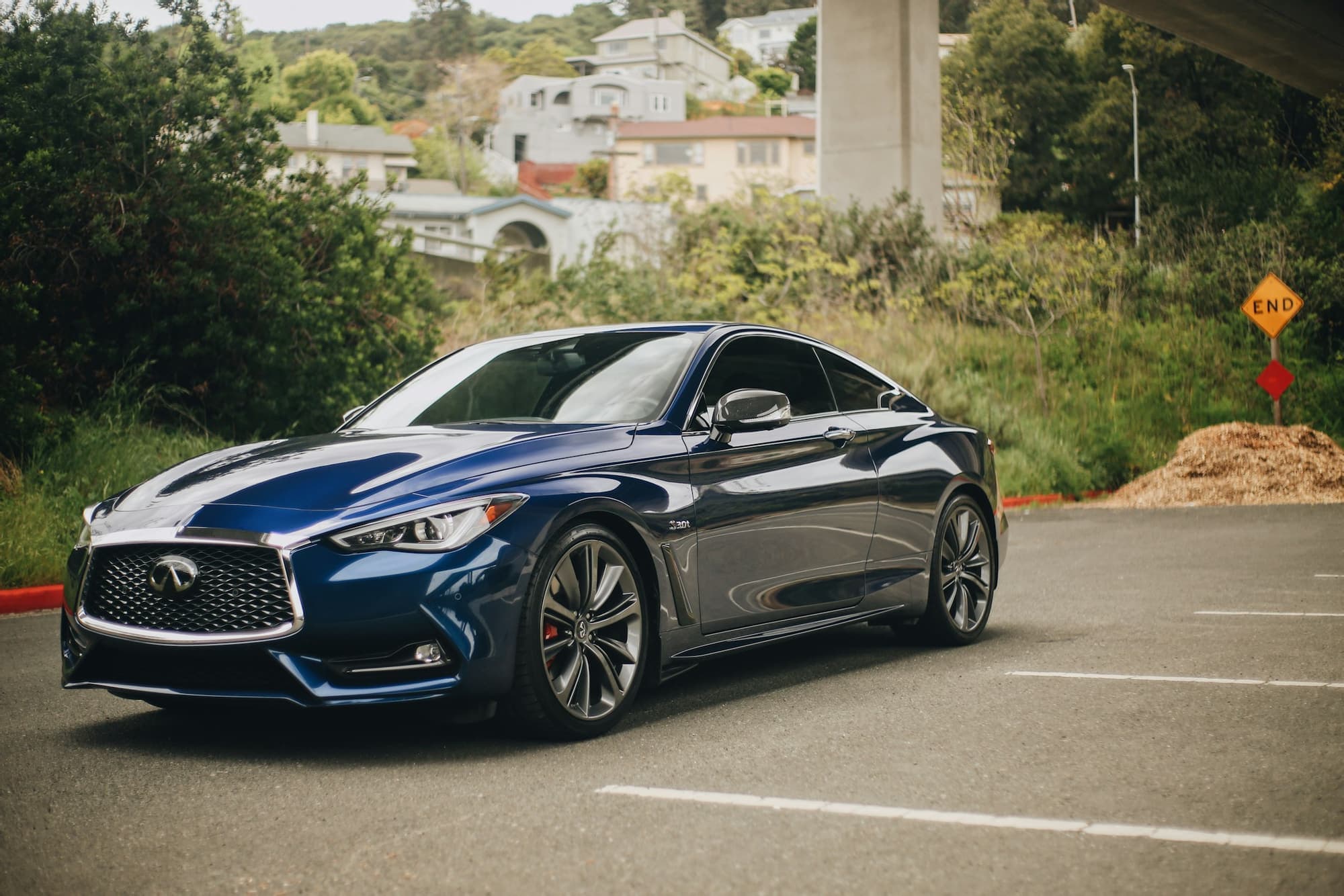Navy blue Infiniti coupe parked on a sunlit driveway
