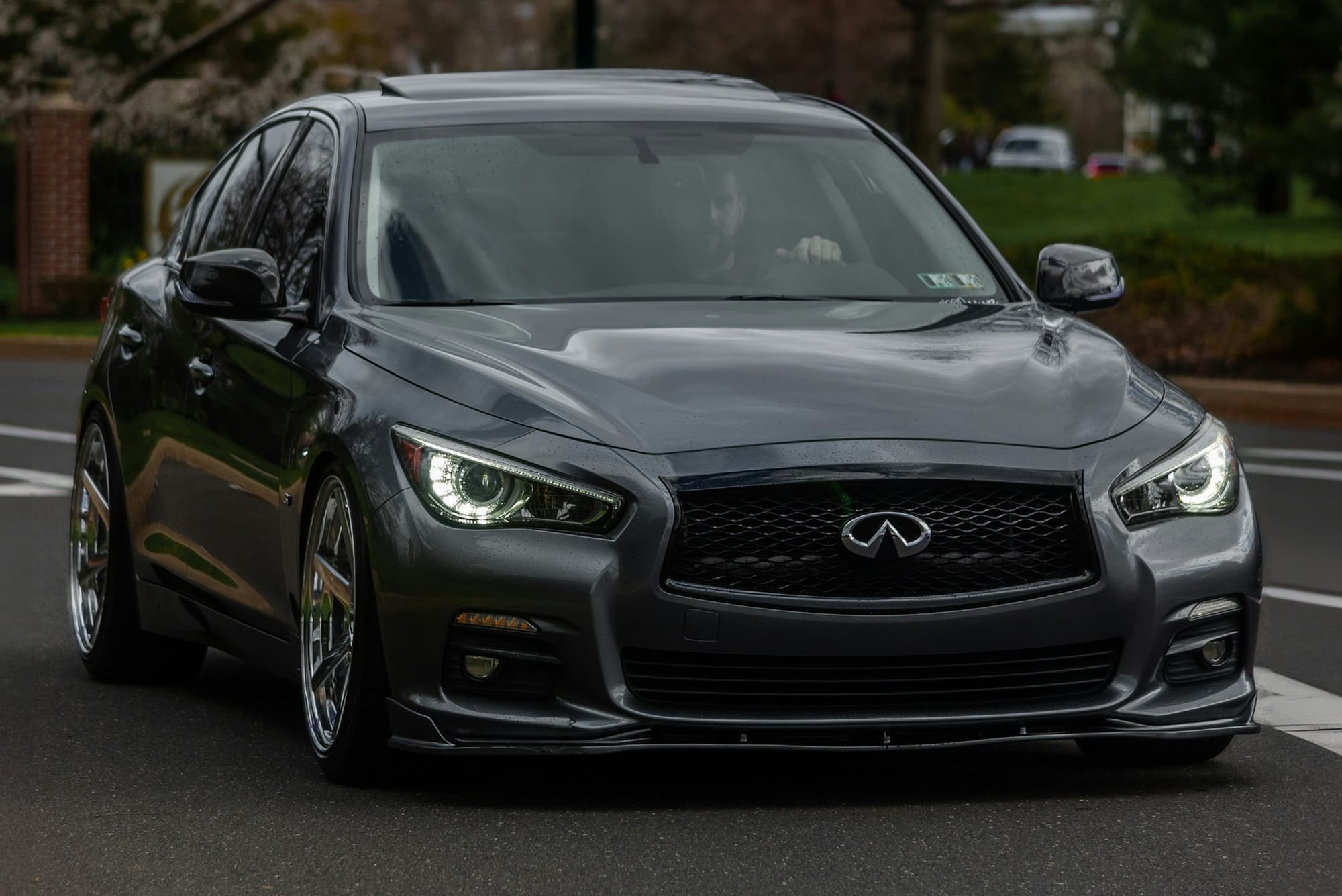 Charcoal Infiniti sedan facing the camera on a city street
